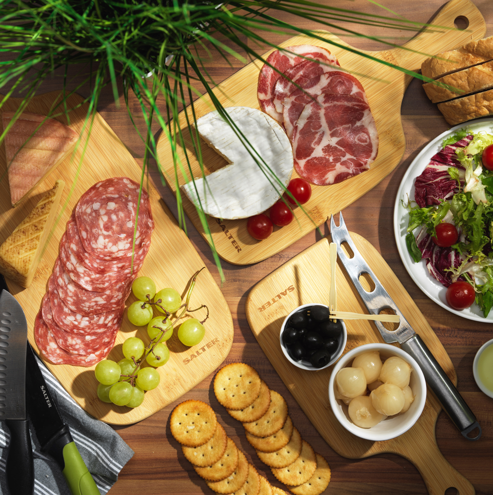 Salami, grapes and crackers on salter wooden boards