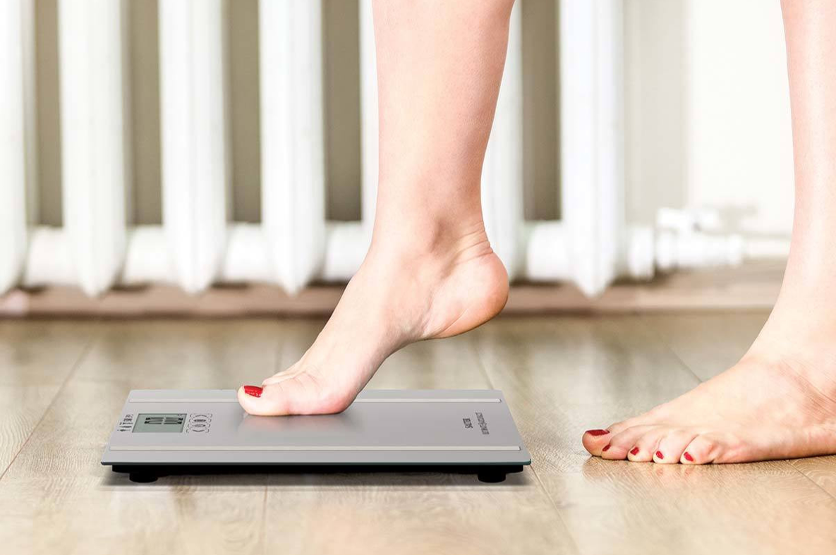 A woman stepping onto a scale