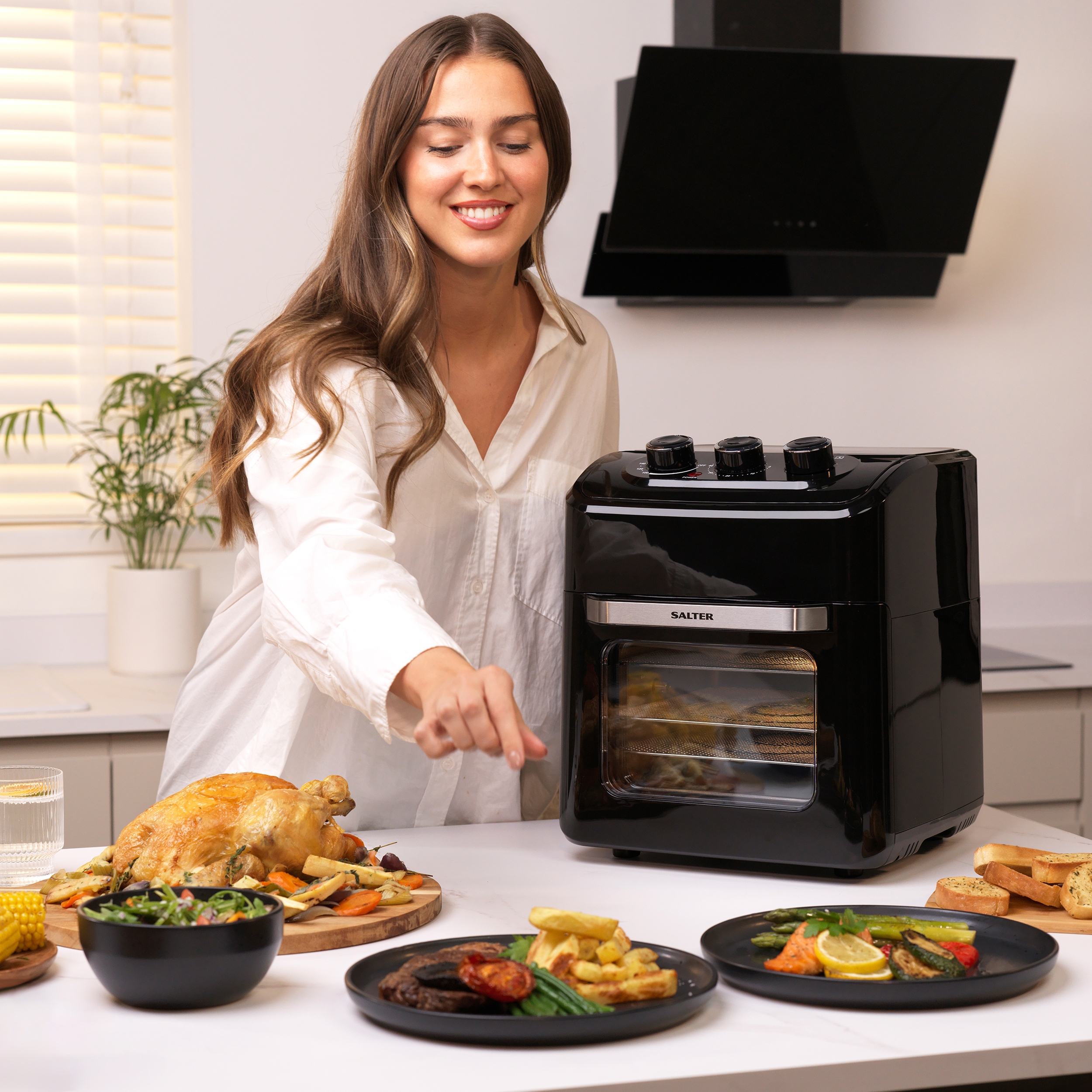 A woman using a Dual View Air Fryer oven in a kitchen
