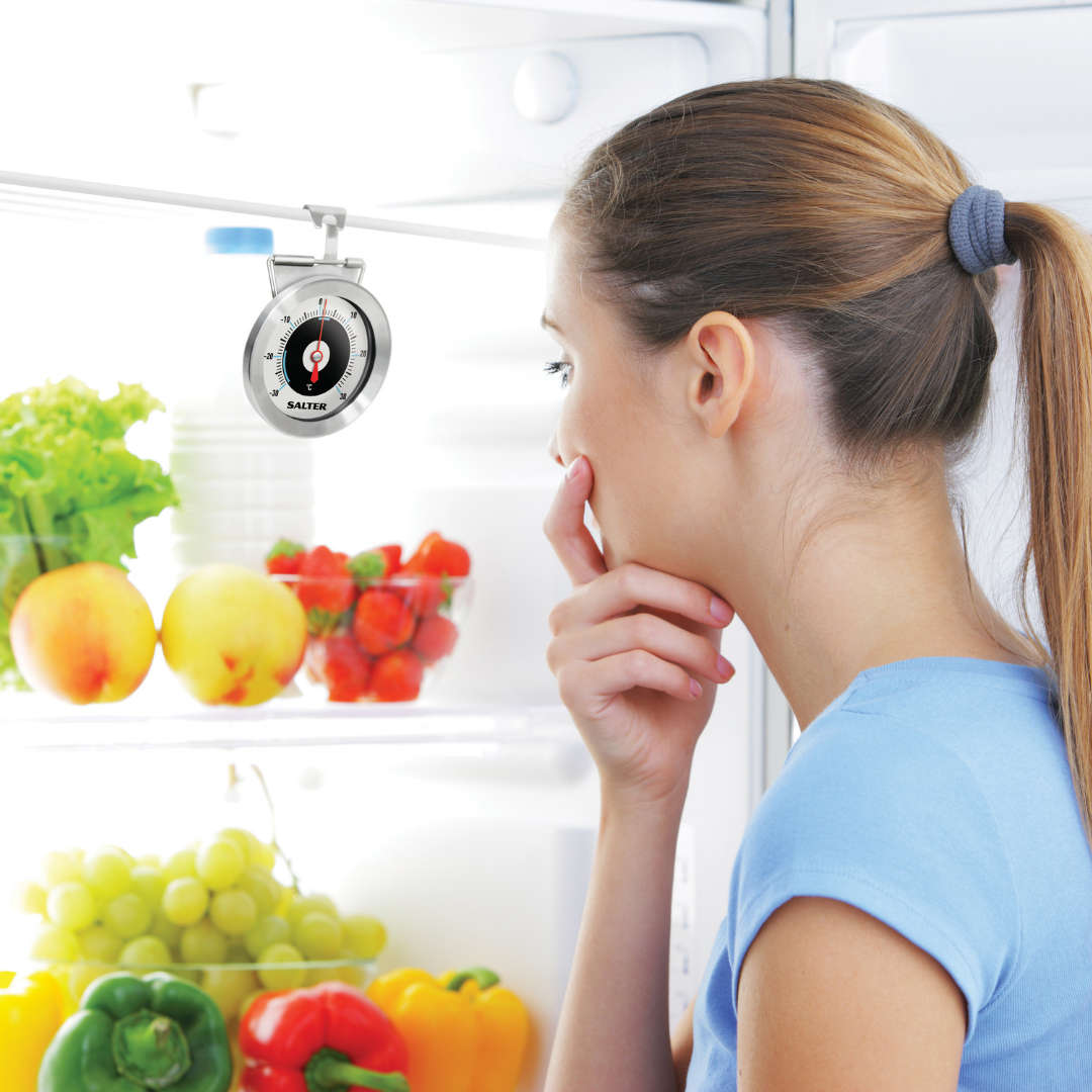A woman looking into an open fridge at a Salter fridge thermometer 