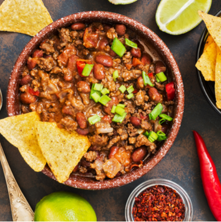 A bowl of Pumpkin Chilli with tacos and dip