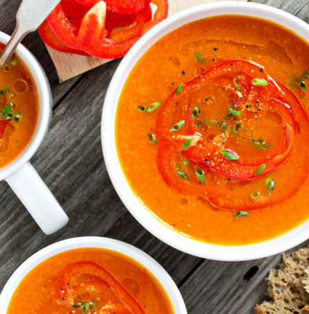 Pumpklin soup in a bowl with peppers on top