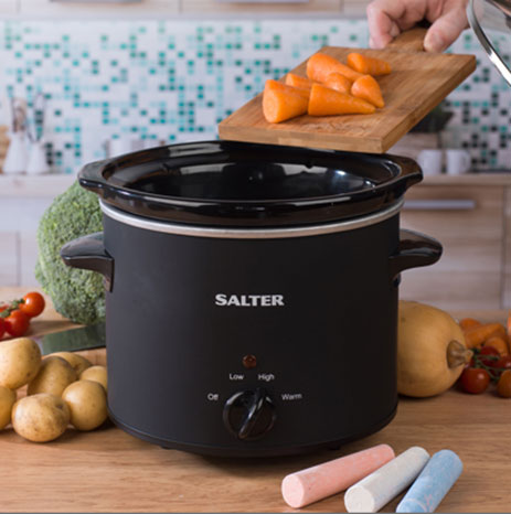 A Black salter chalkboard slow cooker with carrots being put into it